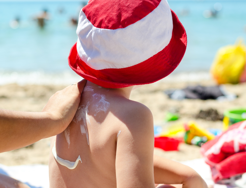 Young boy having sunscreen applied